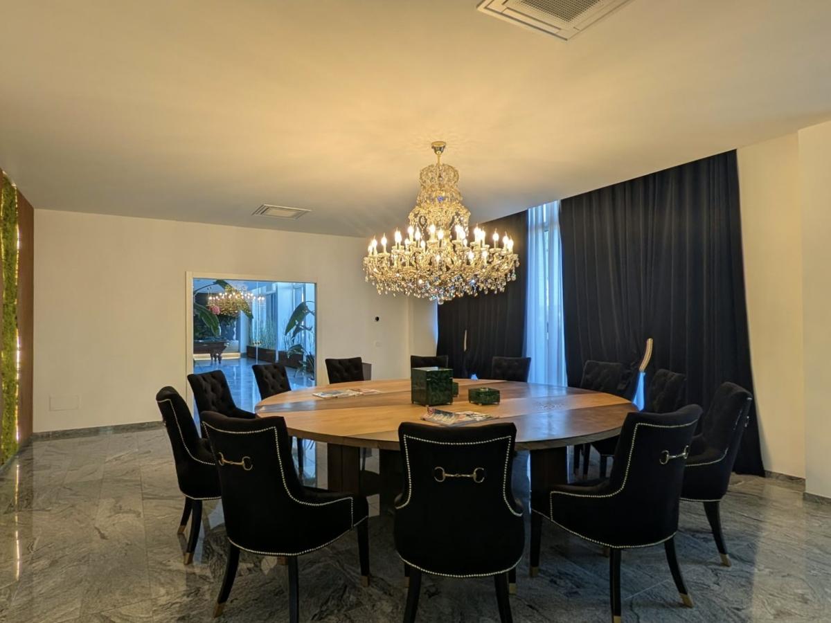 Sala Meeting Magrini Energia · Tavolo riunioni con sedute in velluto nero e parete verde